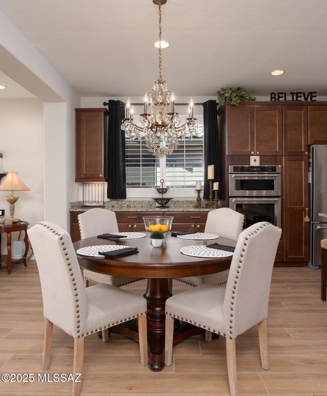 dining room with a chandelier and light wood-type flooring