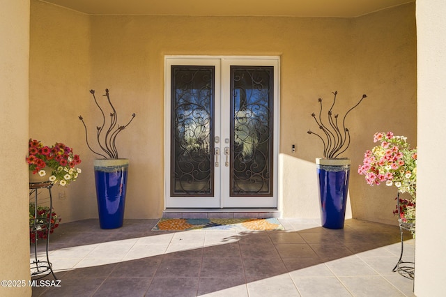 property entrance with stucco siding and french doors