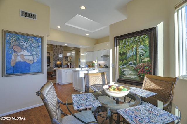 dining space with baseboards, visible vents, wood finished floors, and recessed lighting