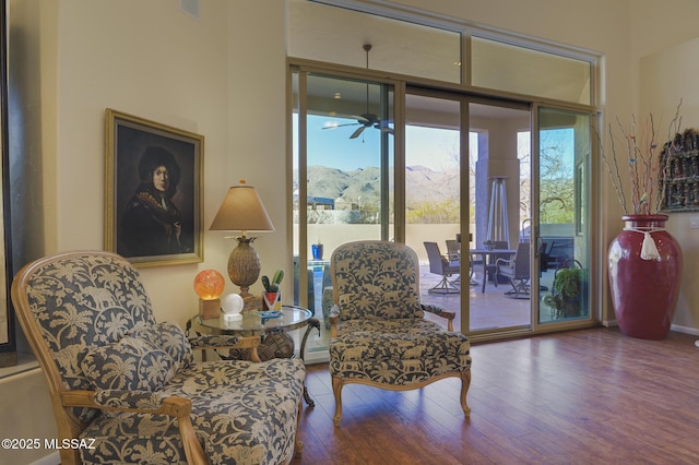 sitting room with a ceiling fan and wood finished floors