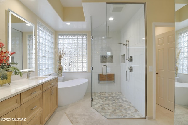 full bathroom with a stall shower, a soaking tub, plenty of natural light, and vanity