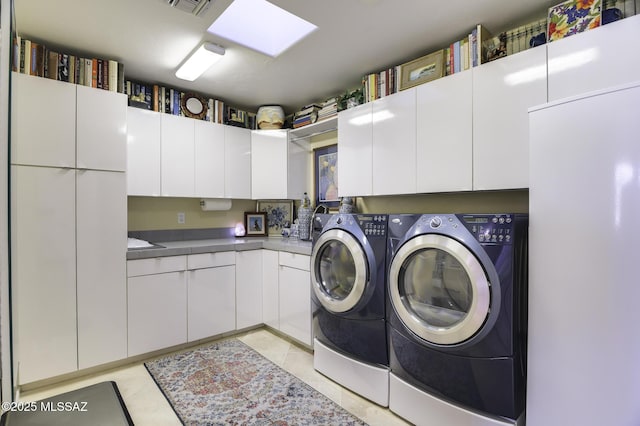 laundry room with light tile patterned floors, cabinet space, and independent washer and dryer