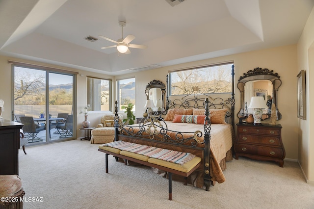 bedroom featuring access to exterior, visible vents, a raised ceiling, and light colored carpet