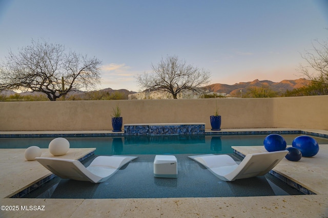 view of swimming pool featuring a mountain view, a fenced in pool, and a patio