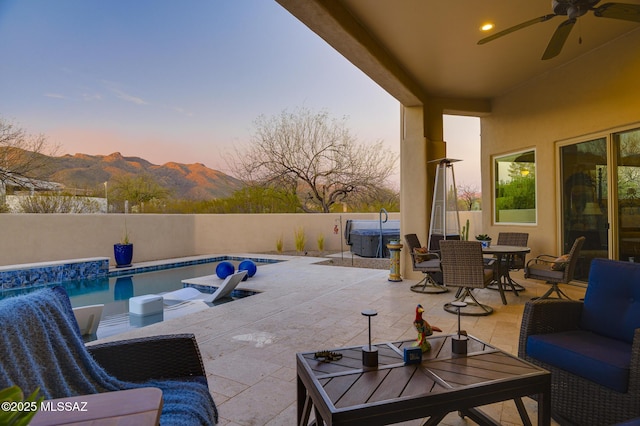 view of patio with fence private yard, a mountain view, a ceiling fan, a fenced in pool, and outdoor dining space