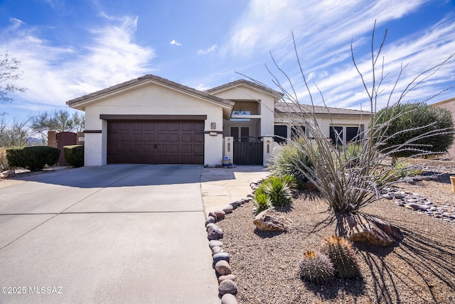 view of front of property featuring an attached garage, driveway, and stucco siding