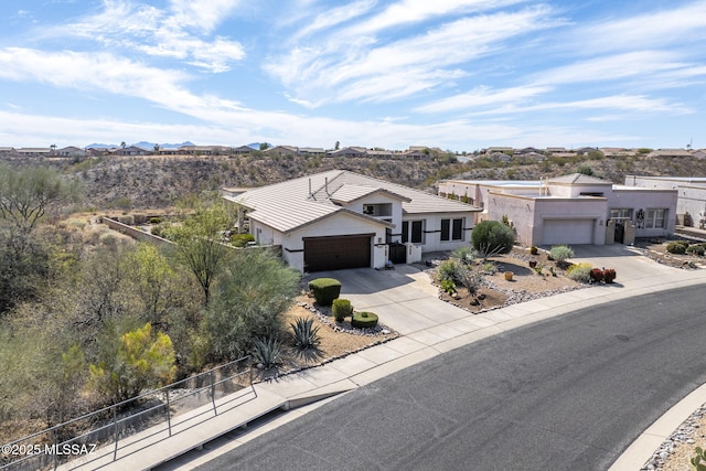 view of front of house with a garage, a tile roof, fence, concrete driveway, and stucco siding