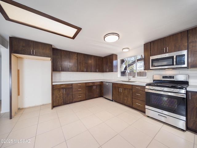 kitchen featuring stainless steel appliances, dark brown cabinets, and light countertops