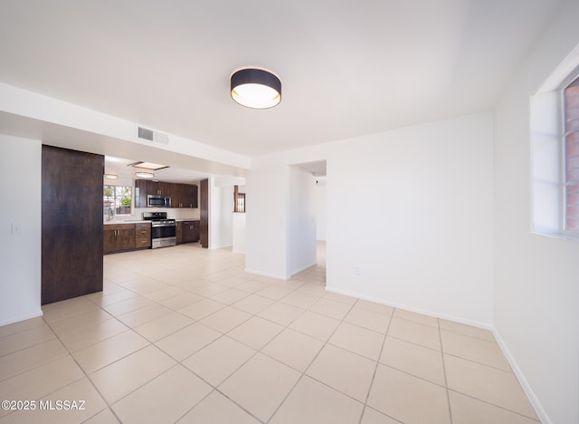 empty room featuring visible vents, baseboards, and light tile patterned floors