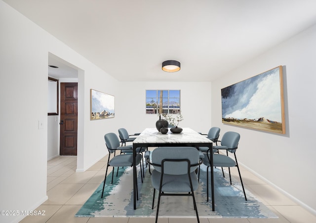 dining space with baseboards and light tile patterned floors