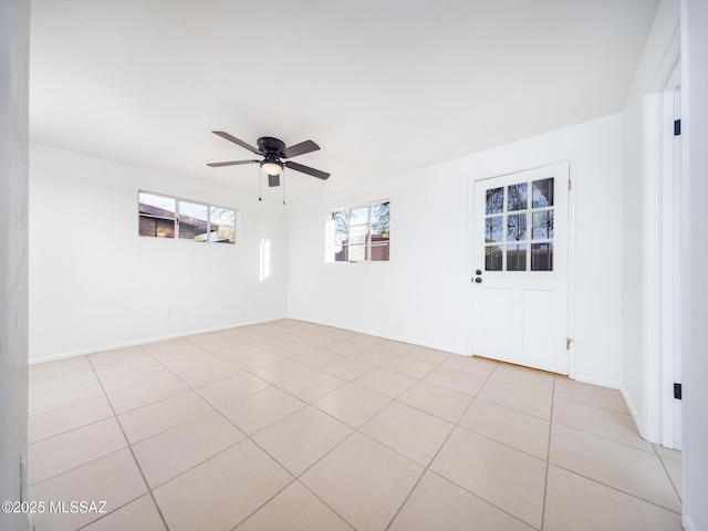 spare room featuring light tile patterned floors, baseboards, and a ceiling fan