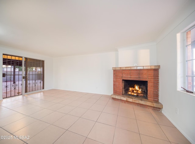 unfurnished living room featuring light tile patterned floors, a fireplace, and crown molding