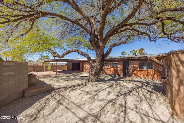 exterior space featuring brick siding and fence