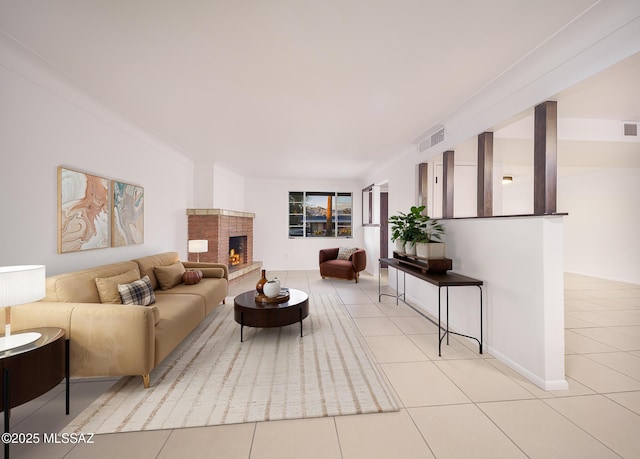 living area featuring crown molding, visible vents, a fireplace, and light tile patterned floors