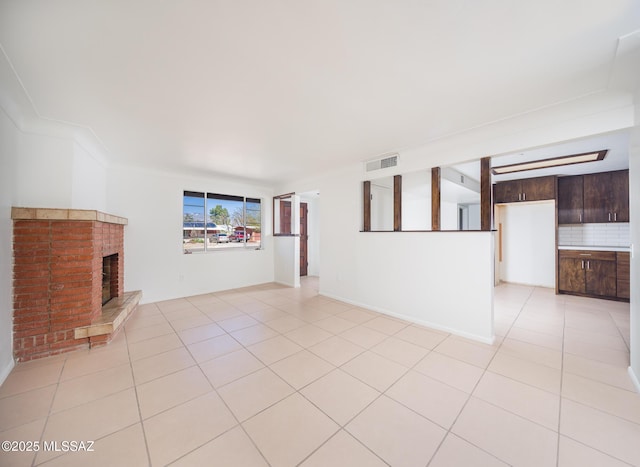 unfurnished living room featuring visible vents, a fireplace, and light tile patterned floors