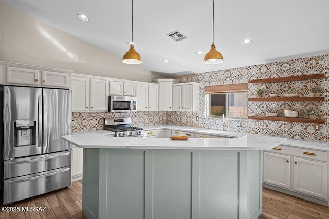 kitchen featuring open shelves, stainless steel appliances, light wood-style flooring, and a sink