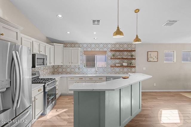 kitchen featuring backsplash, lofted ceiling, visible vents, and stainless steel appliances