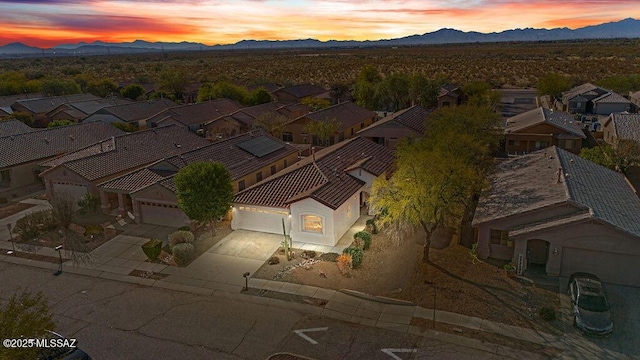 back of property at dusk with fence, a tiled roof, stucco siding, and a patio