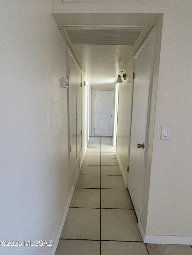 hall with baseboards and light tile patterned floors