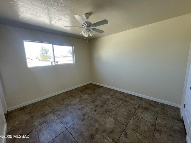 spare room with ceiling fan, a textured ceiling, and baseboards