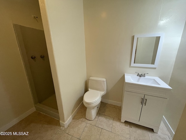 bathroom with tile patterned flooring, toilet, vanity, baseboards, and a shower stall