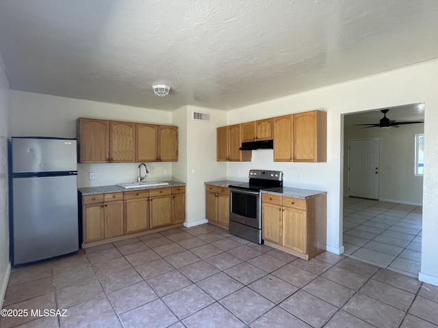 kitchen with under cabinet range hood, stainless steel appliances, a sink, visible vents, and light countertops