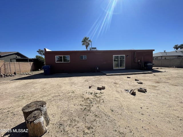 rear view of property featuring a patio area and fence