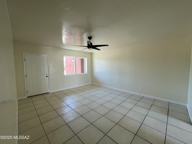 empty room with a ceiling fan, baseboards, and light tile patterned floors