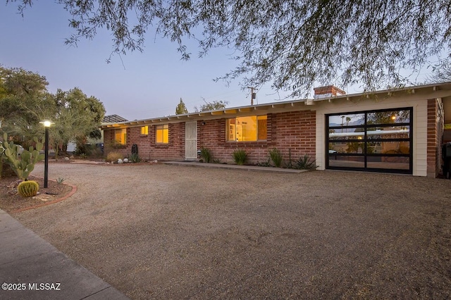 single story home featuring brick siding and driveway