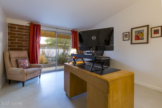 office space featuring lofted ceiling, concrete floors, and baseboards