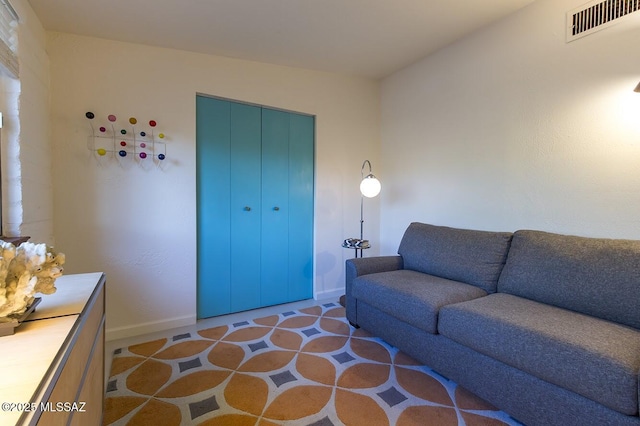 living area featuring baseboards and visible vents