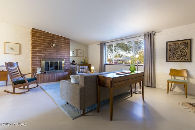 living area with lofted ceiling, a fireplace, and finished concrete flooring