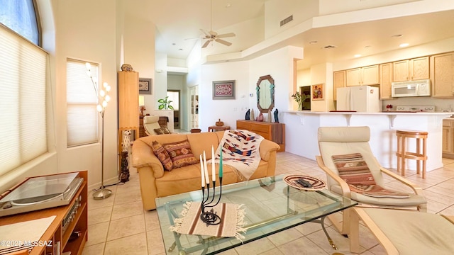 living area with a high ceiling, a wealth of natural light, and a ceiling fan