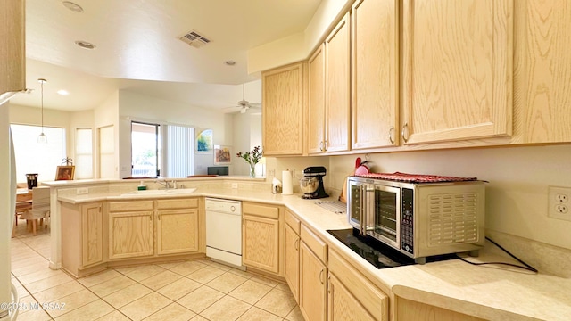 kitchen featuring stainless steel microwave, dishwasher, a peninsula, and light brown cabinetry