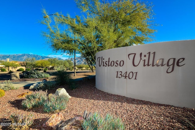 community / neighborhood sign with a mountain view