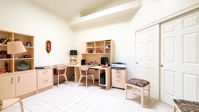 office space with vaulted ceiling and light tile patterned floors