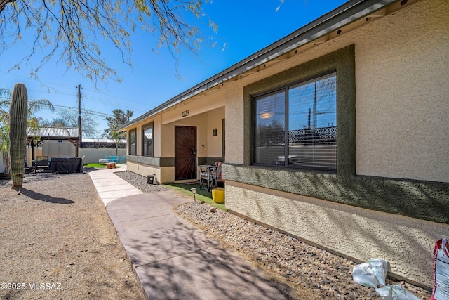 exterior space with a patio, an outdoor structure, and stucco siding