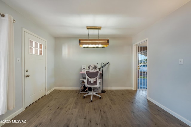 unfurnished dining area with dark wood-style floors and baseboards