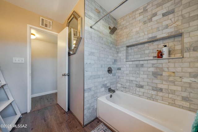 bathroom with shower / washtub combination, visible vents, and wood finished floors