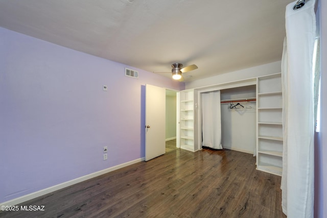 unfurnished bedroom with ceiling fan, visible vents, baseboards, a closet, and dark wood-style floors