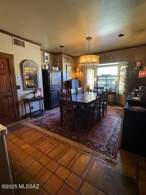 dining area featuring ornamental molding, a chandelier, and visible vents