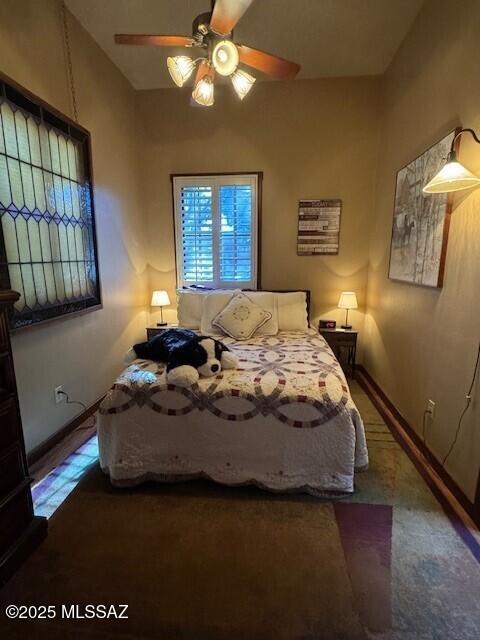 bedroom with carpet, baseboards, and a ceiling fan