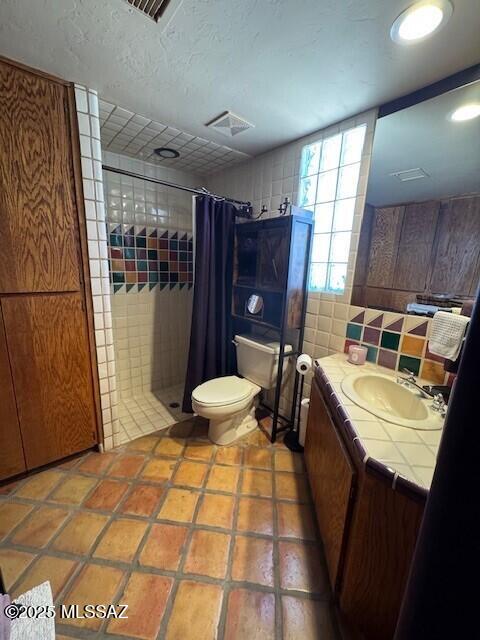 full bathroom featuring visible vents, backsplash, toilet, a stall shower, and vanity