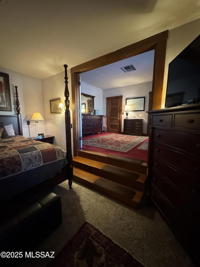 carpeted bedroom featuring visible vents