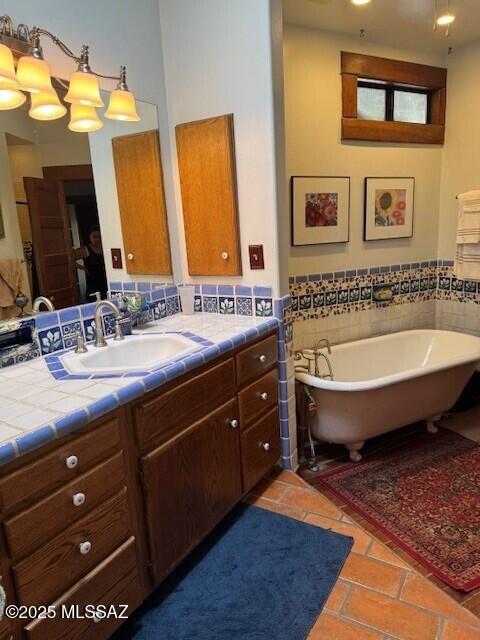 full bath featuring a wainscoted wall, a soaking tub, vanity, and tile patterned floors