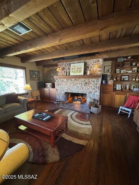 living area with wood finished floors, wooden ceiling, a fireplace, and visible vents