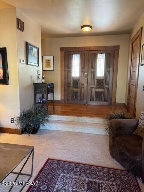 foyer with baseboards and wood finished floors