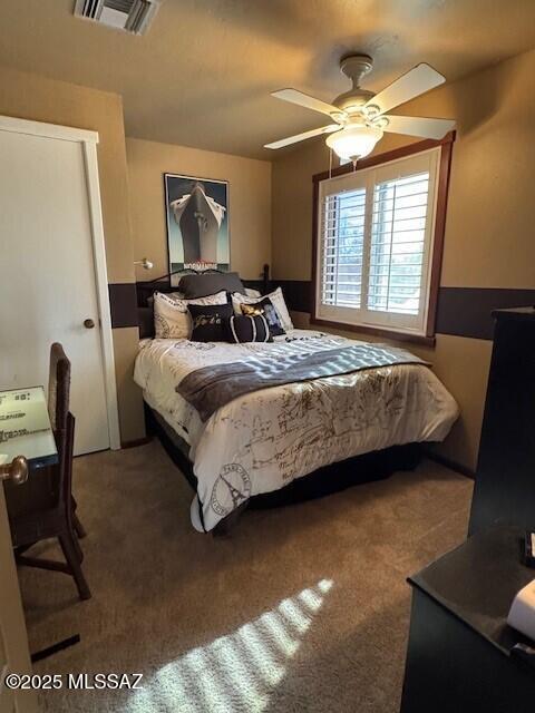 carpeted bedroom featuring a ceiling fan and visible vents