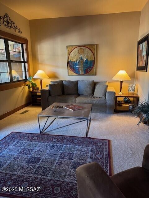 living area featuring carpet floors, visible vents, and baseboards