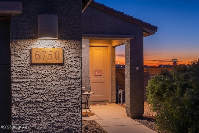 property entrance with stucco siding